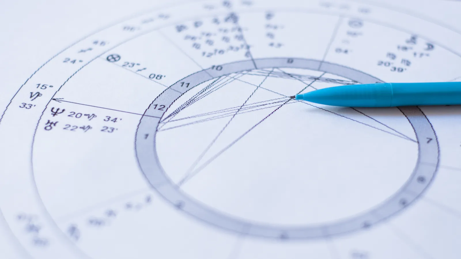 natal chart free: Hands tracing a free natal chart wheel beside glowing zodiac constellations